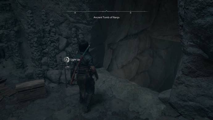 Naoe looking at a chest in a cave in Assassin’s Creed Shadows.