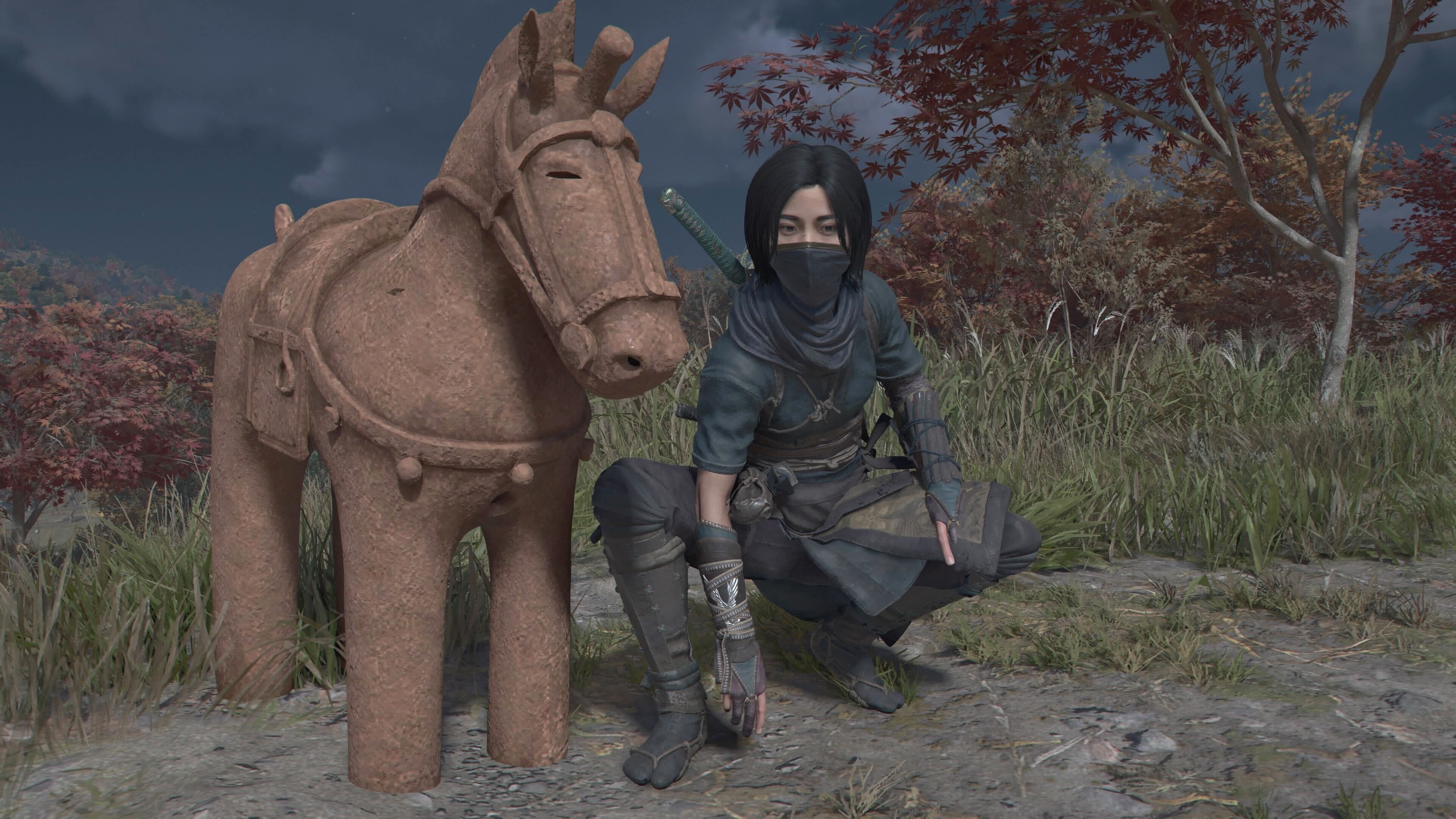 Naoe crouching beside a horse statue in Assassin&rsquo;s Creed Shadows.