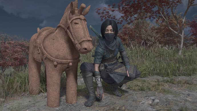 Naoe crouching beside a horse statue in Assassin’s Creed Shadows.