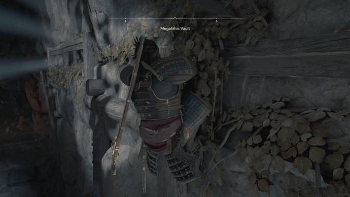 Yasuke climbing a ledge inside the Megalithic Vault Kofun in Assassin’s Creed Shadows.