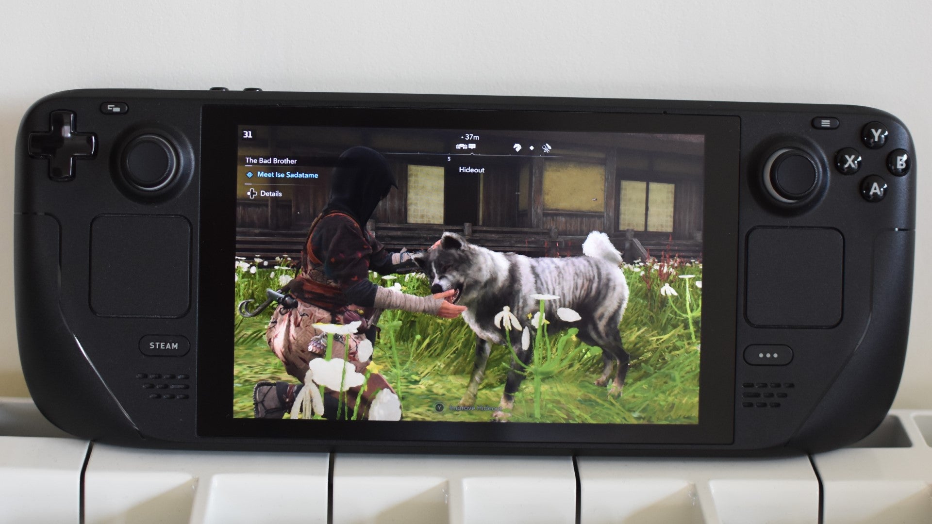 Naoe pets a dog in Assassin&rsquo;s Creed Shadows, running on a Steam Deck.