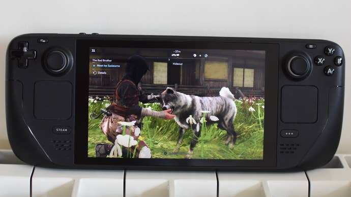 Naoe pets a dog in Assassin’s Creed Shadows, running on a Steam Deck.