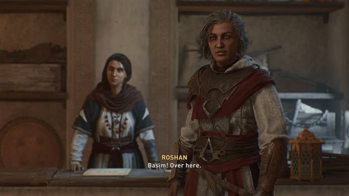 Roshan beckons Basim over to her and Rebekah in a Hidden Ones Bureau in Assassin's Creed Mirage