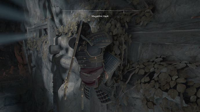 Yasuke, der im Megalithic Vault Kofun in Assassin's Creed Shadows an einer Kante klettert.