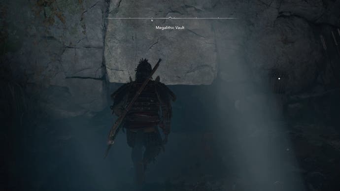 Yasuke next to a space in the wall inside the megalithic vault Kofun in the shadows of Creed of Assassin.