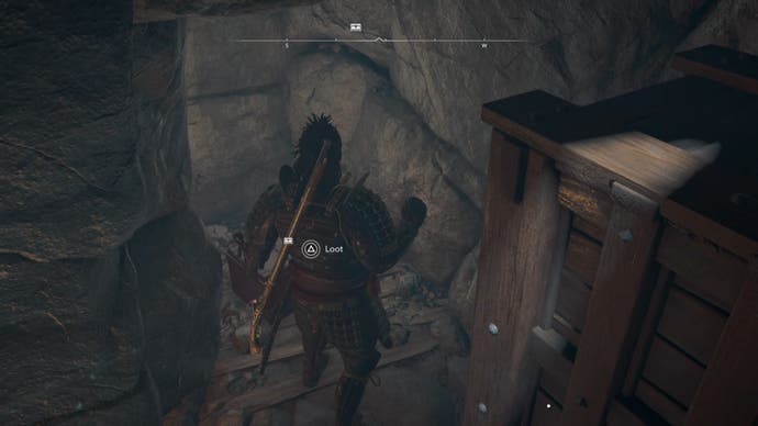 Yasuke next to a wooden block inside the Mégalt Kofun vault in the Shadows of Creed of Assassin.