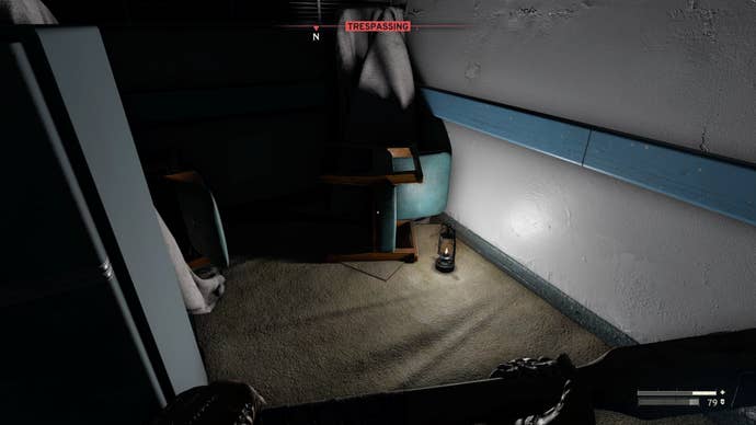 The player looks at a lantern on the floor of the Medical wing in Atomfall’s Interchange; this is where players can find an audio recording and the Church Cellar Key