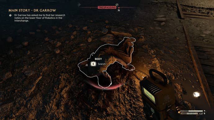 The player looks down at a corpse who holds the Site Office Key in Atomfall