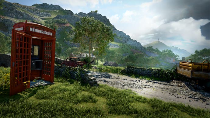 A bright red phone box is in the foreground with beautiful rolling green hills behind it.
