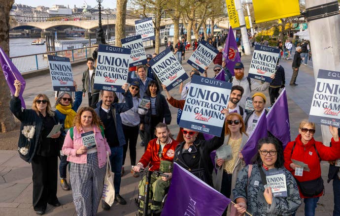 Photo of protestors holding “Union contracts in gaming” placards in a large group