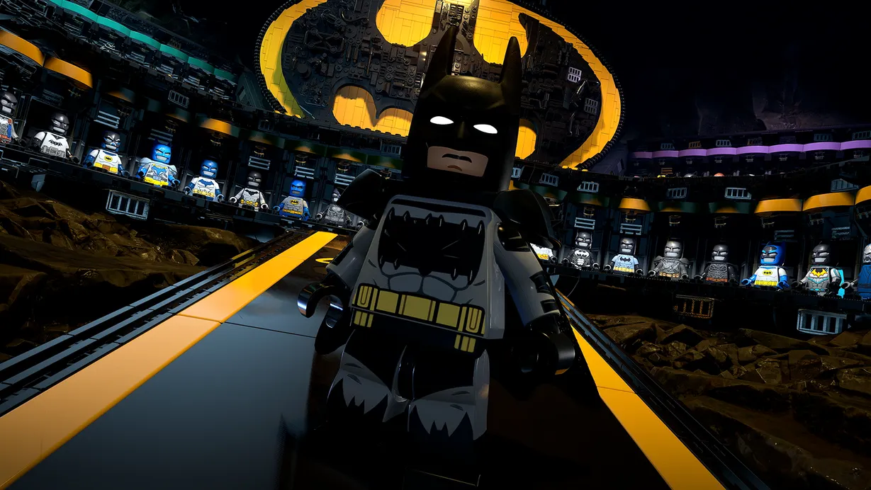 Batman stands in front of his many different Batsuits within the Batcave in Lego Batman Legacy of the Dark Knight