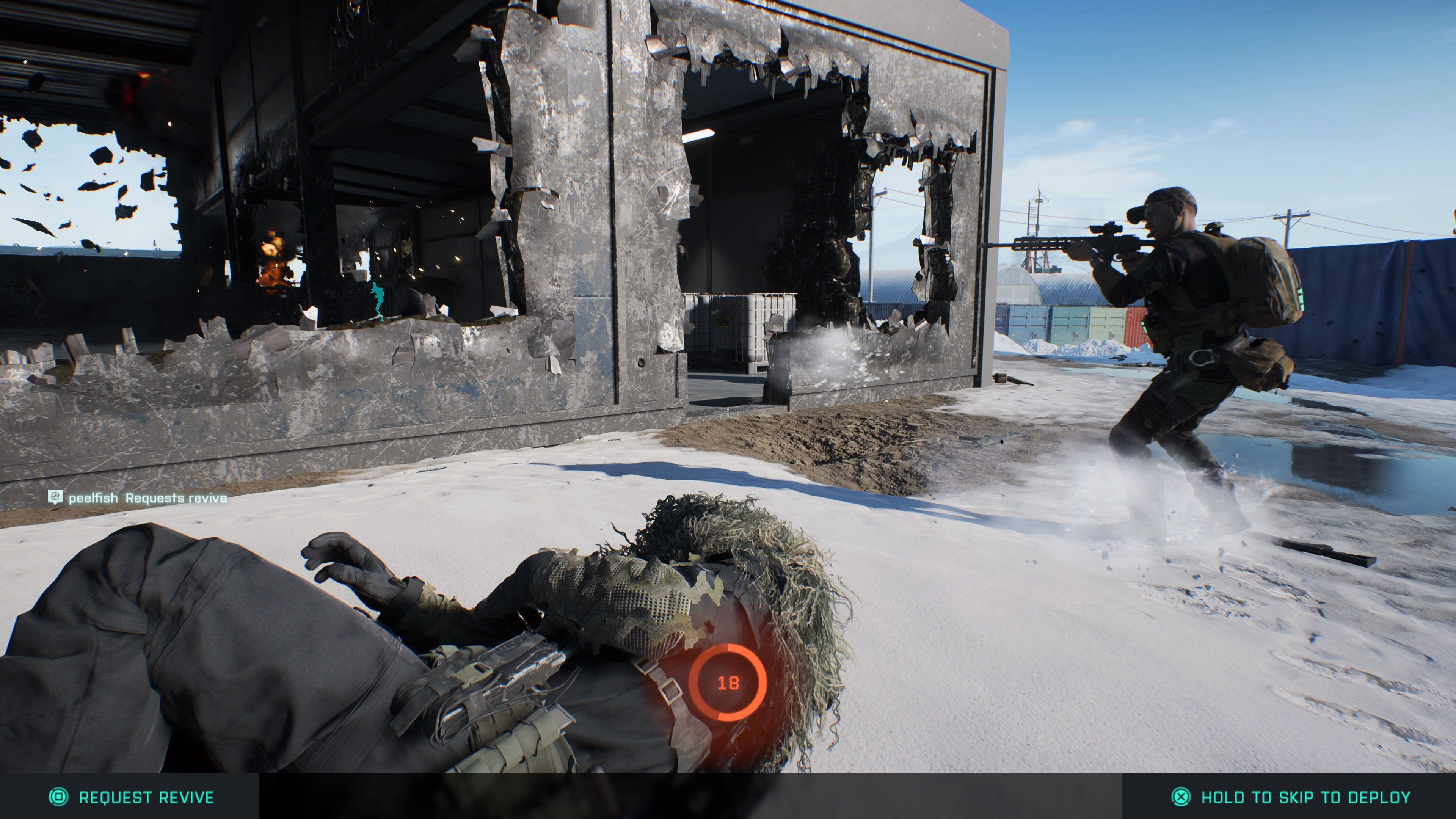 State of the Game Battlefield 2042 - a teammate on the floor in front of you that you&rsquo;re reviving, with another firing through a hole in a destroyed building