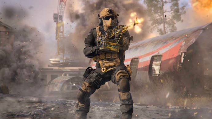 a soldier in light brown gear firing a golden light machine gun with smoke and dust swirling all around a plane crash site