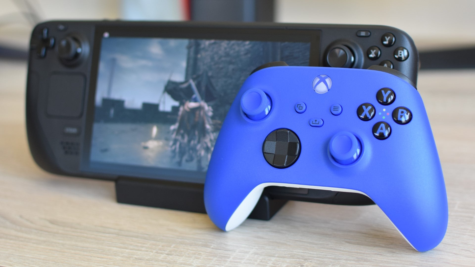 The Microsoft Xbox Wireless Controller (in blue) propped up against a Steam Deck. - 6