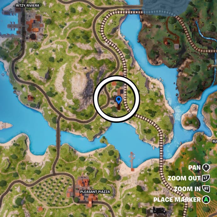 Cropped map view of a circle around a clump of houses by a traintrack in Fortnite.