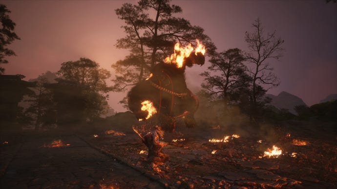 Another shot of Wukong fighting a massive bear in an arena besieged by fire in Black Myth Wukong.