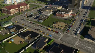 A residential street, dotted with parked cars, in Cities Skylines 2.