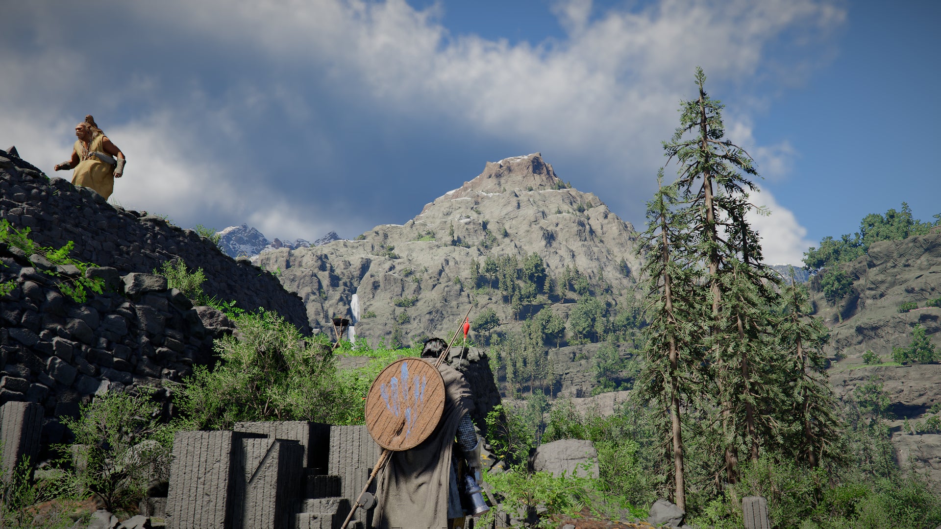 Crimson Desert screenshot showing Kliff looking up at a distain mountain, and a giant up to the left