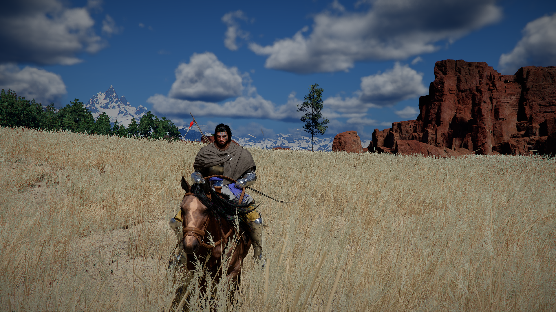 Crimson Desert screenshot showing Kliff riding his horse towards the camera in fields of long dry grass, orange cliffs behind him