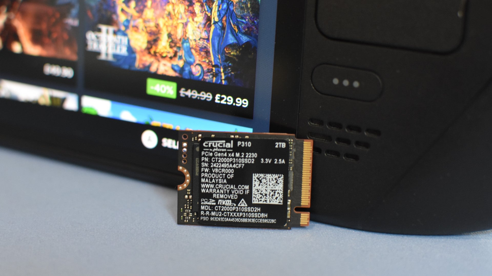 The Crucial P310 SSD propped up against a Steam Deck. - 1