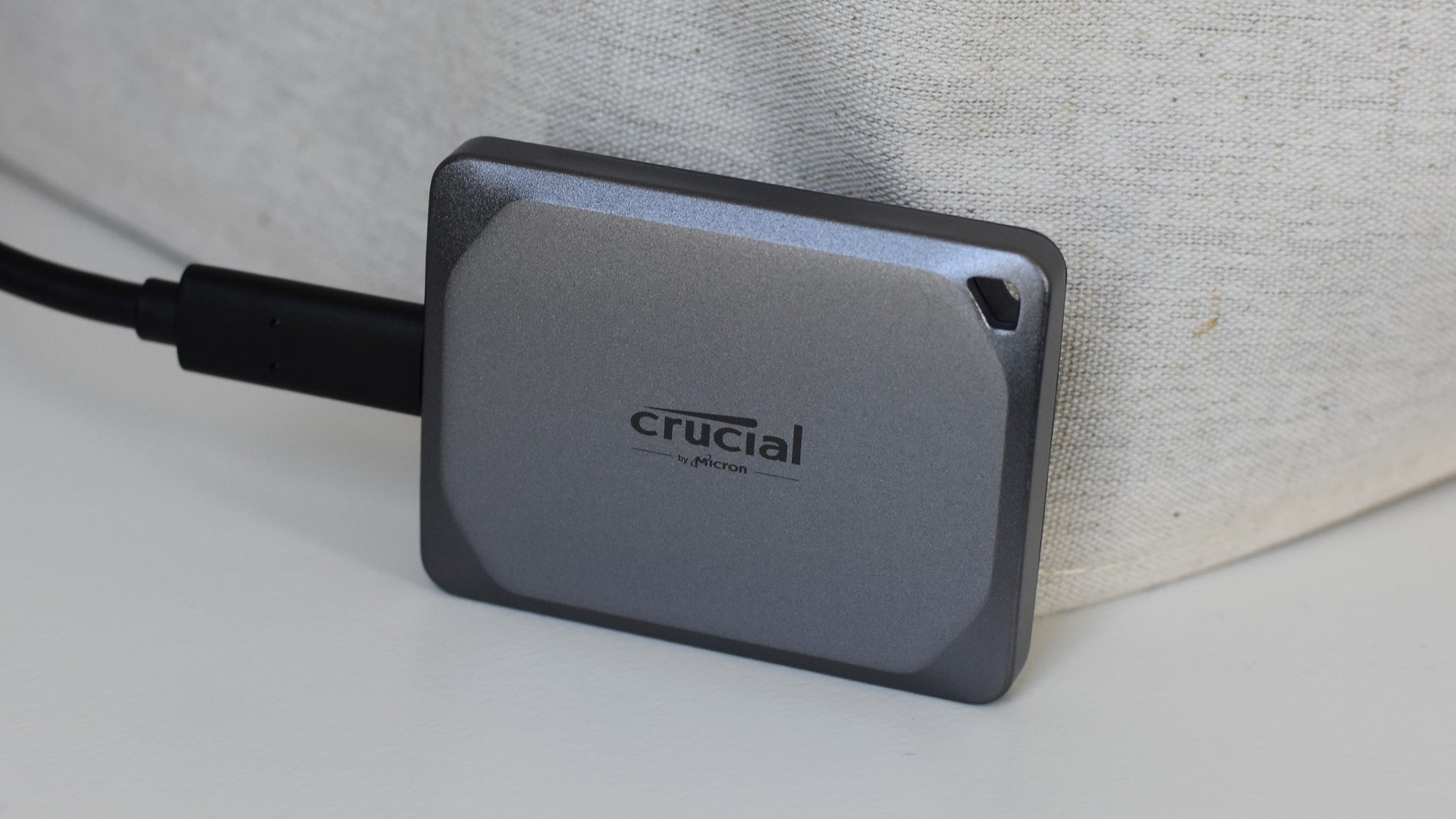 The Crucial X9 Pro SSD on a white table. - 1