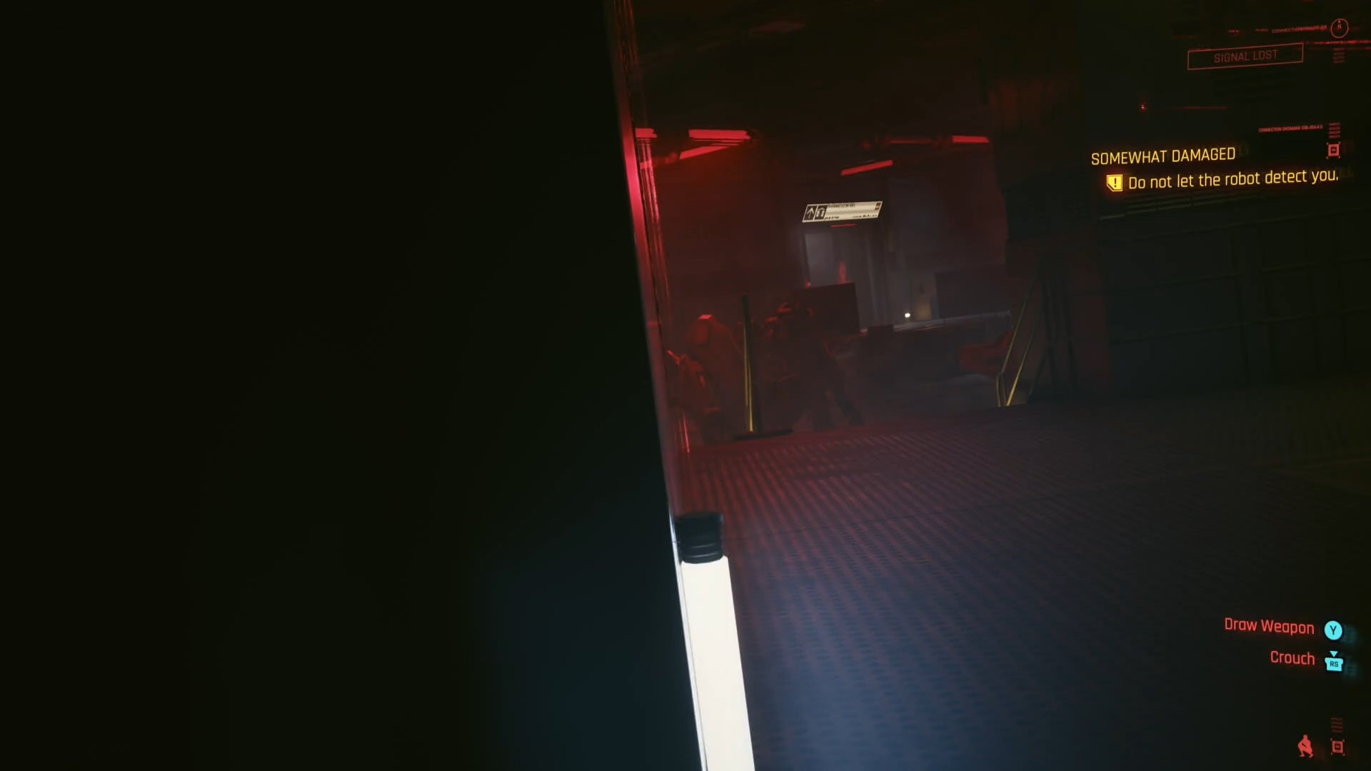 peaking to the right of a large server in a dark room looking at a spider robot far away