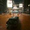 A passing car caught in a puddle’s reflection in Cyberpunk 2077: Phantom Liberty, with DLSS 3.5 Ray Reconstruction switched on.