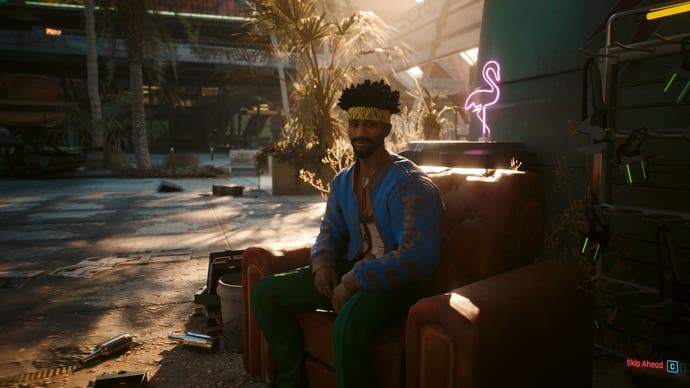 Cyberpunk 2077 Phantom Liberty screenshot showing someone sat on a couch outside in Dogtown