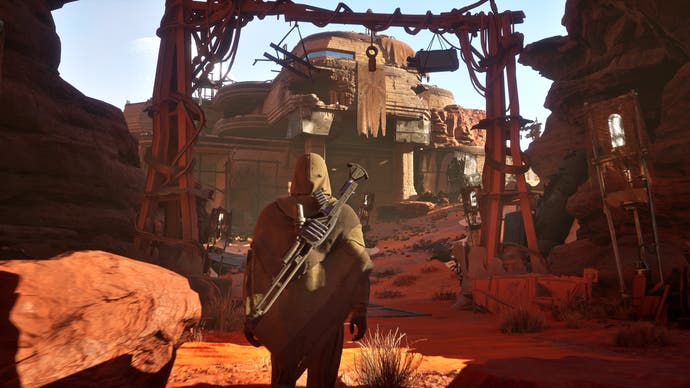 Dune: Awakening in-engine screenshot without the UI showing a player character looking towards a brown building in the desert rocks