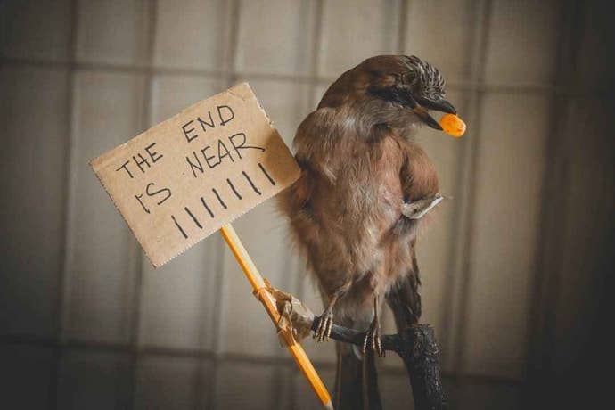 A bird holds a sign in its feet that says “The End is near!” at a Disco Elysium LARP.