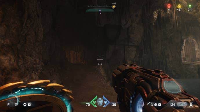 The player - who is inside a cave in The Siege Part 1 chapter - looks down a path to their left in DOOM: The Dark Ages