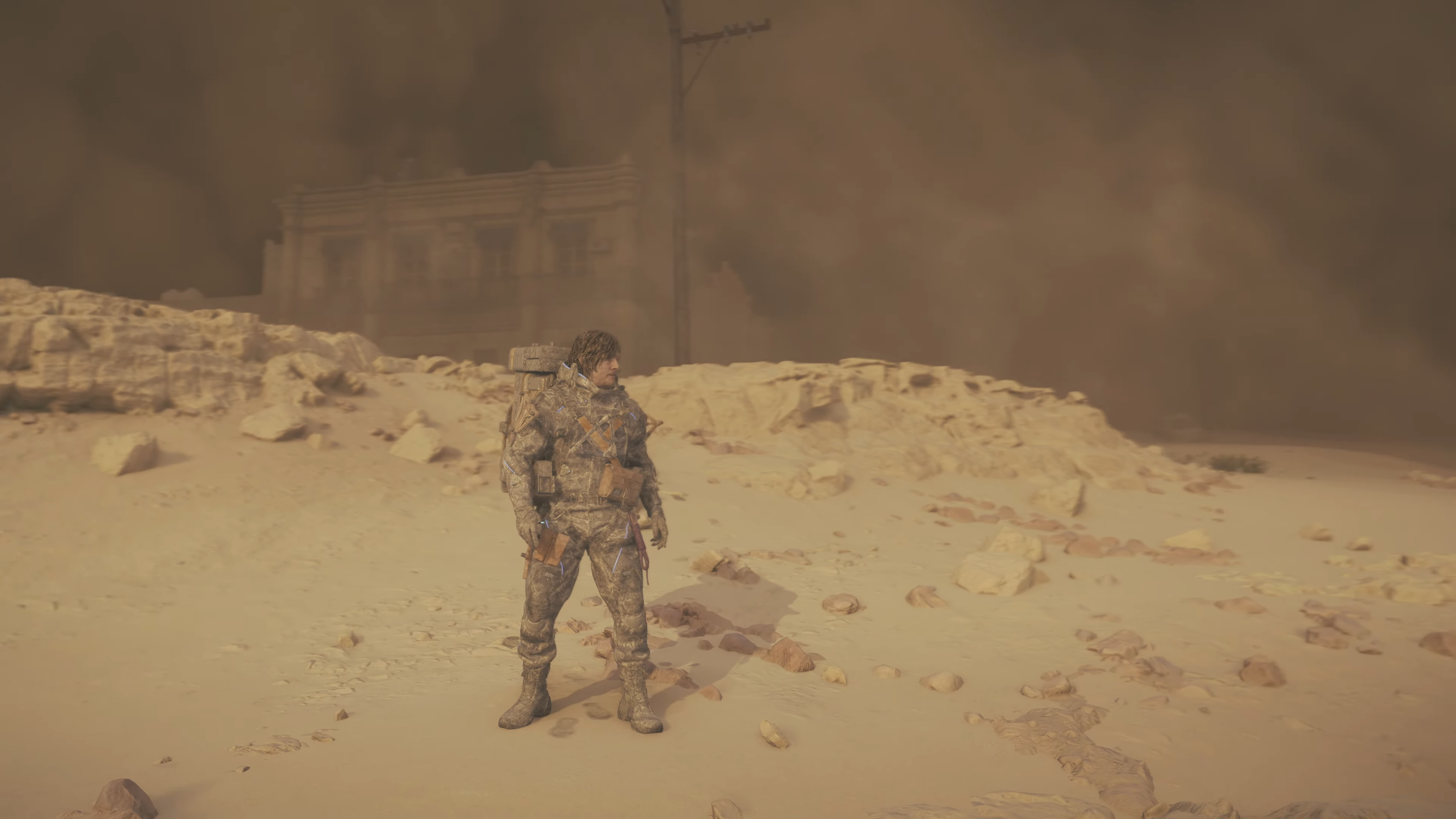 death stranding 2 screenshot - a sand storm coats Sam in dust from head to toe