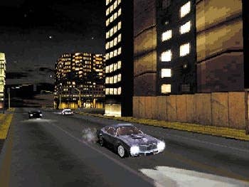The player drives along a long stretch of road at night in Driver
