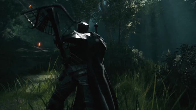 Player in dark armour holds aloft an elaborate crossbow in a forest
