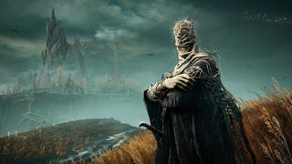An NPC with worms on his head is in the foreground, while in the background is the Pillar of Suppression and a large jagged mountain in Elden Ring: Shadow of the Erdtree.