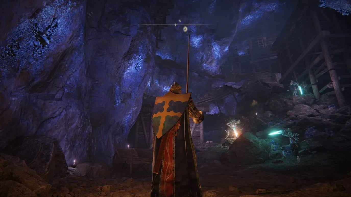 An armoured main character with a large shield on their back standing in the Sellia Crystal Tunnel in Elden Ring.