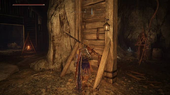 An armoured main character with a large shield on their back standing in the Sellia Crystal Tunnel in Elden Ring.