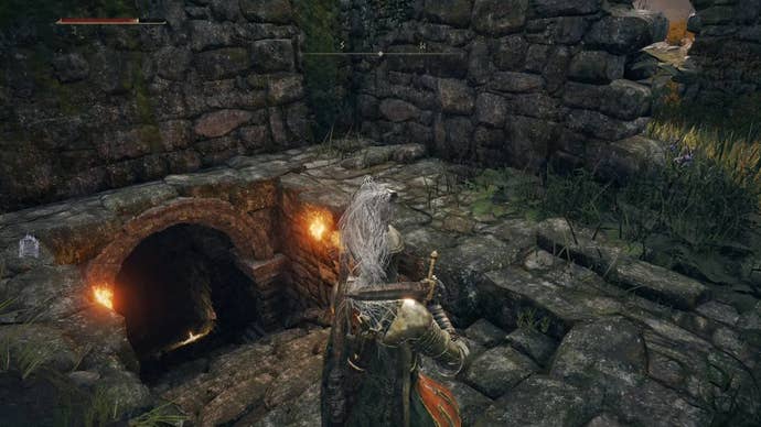 Armoured character in Elden Ring looking at the dungeon entrance to the Waypoint Ruins.