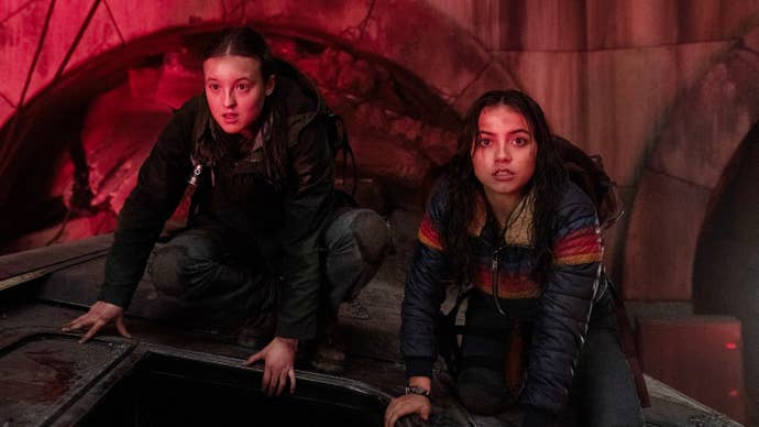 Ellie and Dina in the Seattle subway lit by the red light of a flare