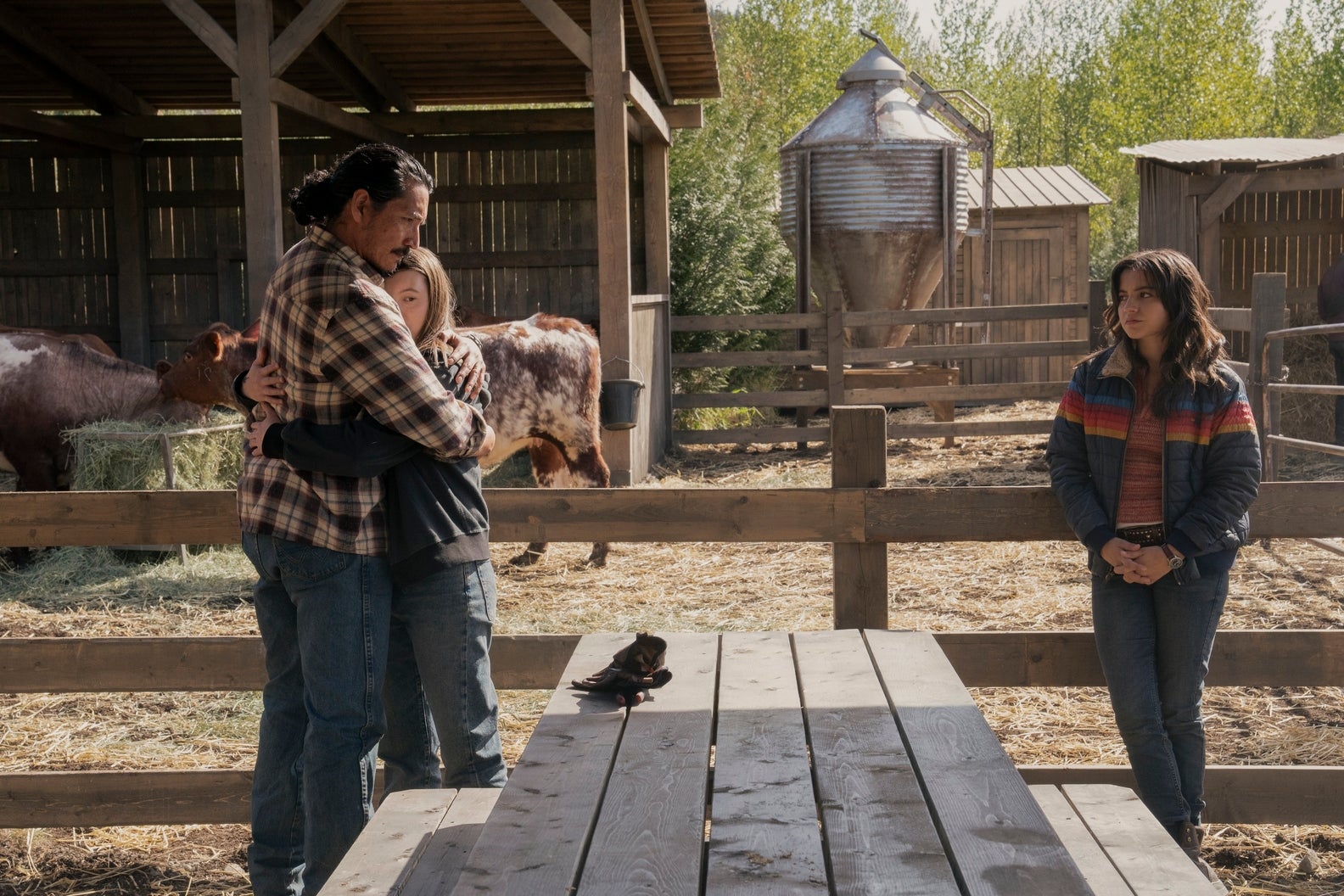 Ellie and Tommy hug as Dina looks on in The Last of Us season two