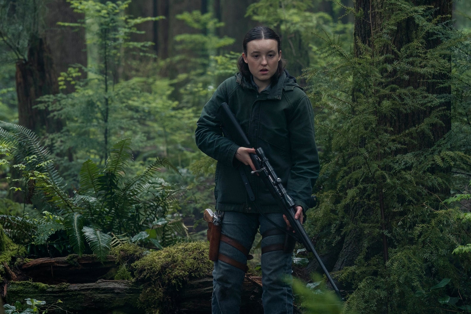 Ellie holds a gun while in the woods in TLOU season two