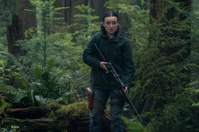 Ellie holds a gun while in the woods in TLOU season two