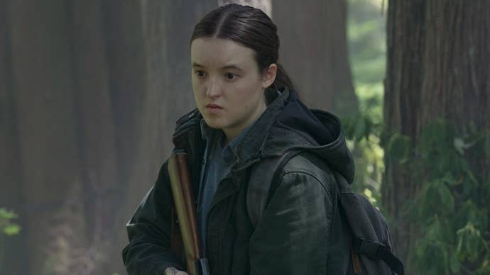 Ellie in TLOU season two stands in the woods holding a gun