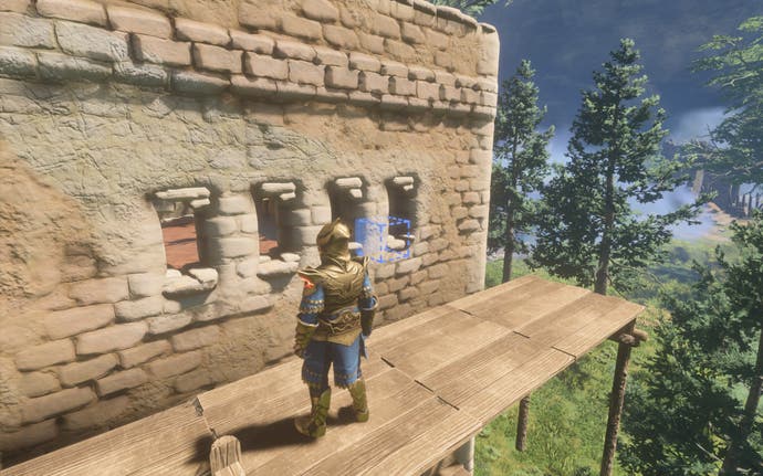 The player-character stands on top of scaffolding, carving some windows into the top of a high sandstone building.