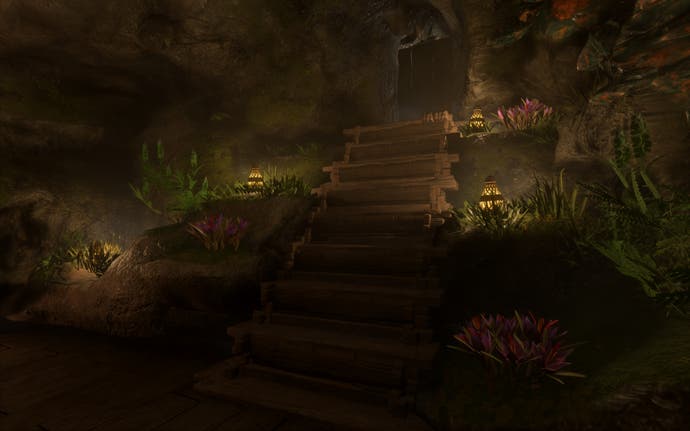 A wooden staircase leads down into an underground room. At the side of the staircase are tufts of grass and flowers, with firefly lamps placed on the floor to create a magical fairy theme.
