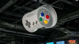 A giant SNES controller, suspended from the ceiling of the Nintendo Museum.