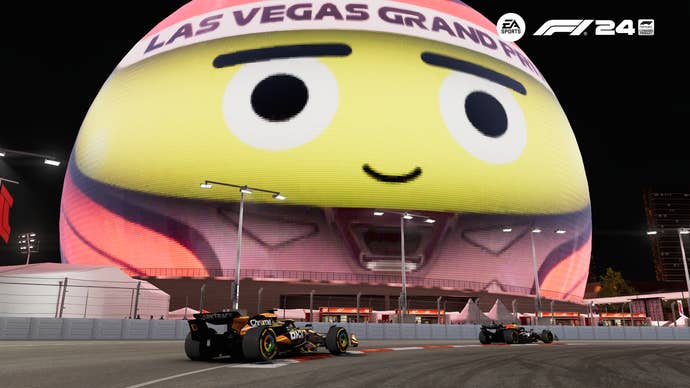 Some F1 cars driving next to the Vegas sphere.