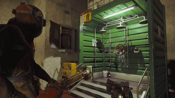 A player in a visor standing next to a green detoxification shower cubicle in Firebreak