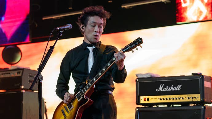 Masayoshi Soken playing electric guitar on-stage with The Primals