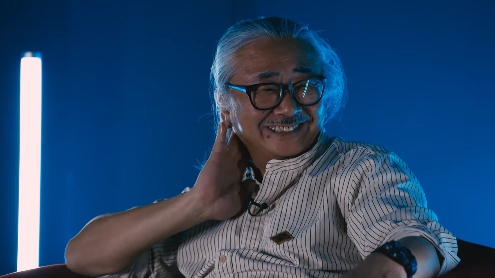 Close up of Final Fantasy composer Nobuo Uematsu on blue background